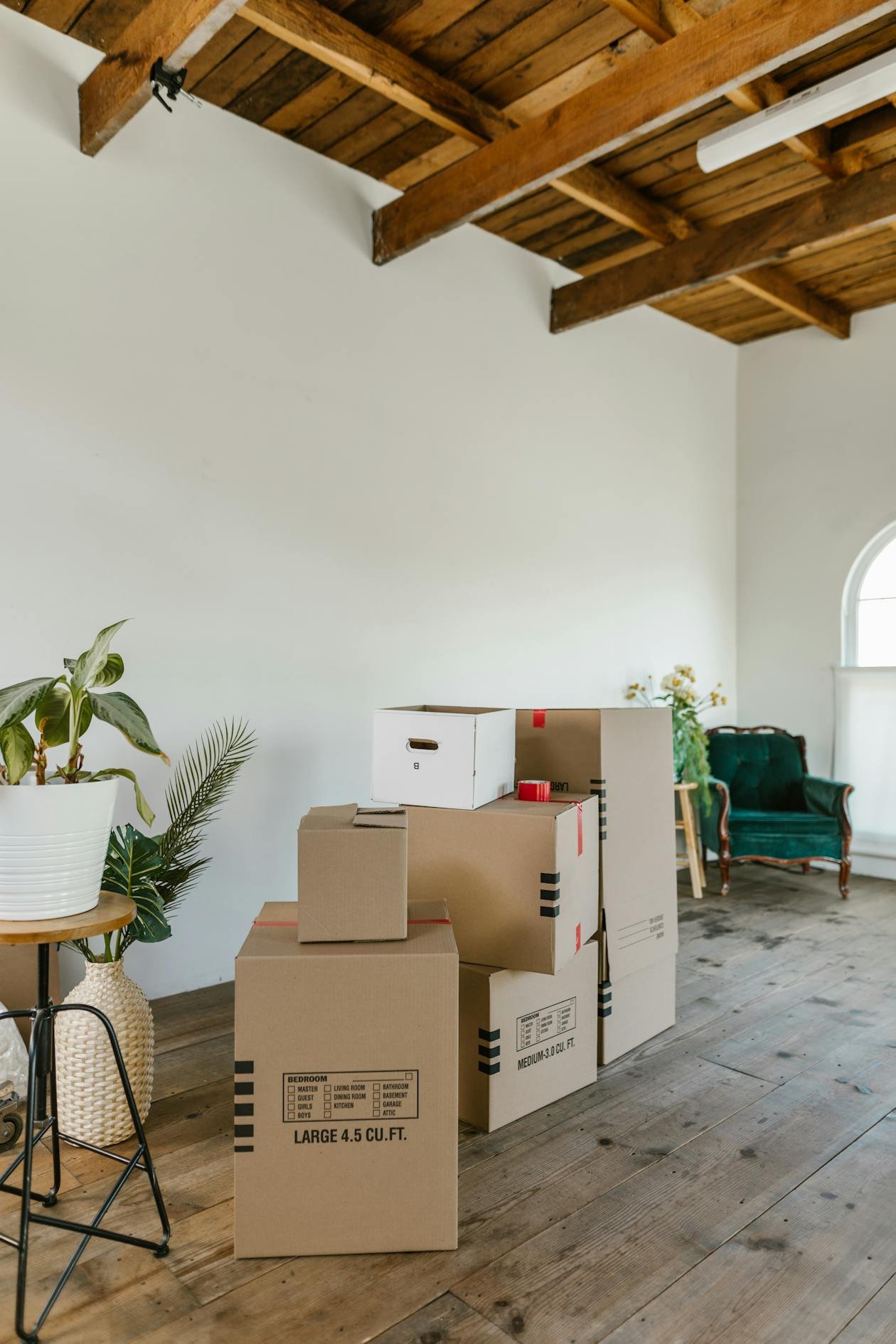 Cardboard moving boxes in an empty sunlit studio apartment
