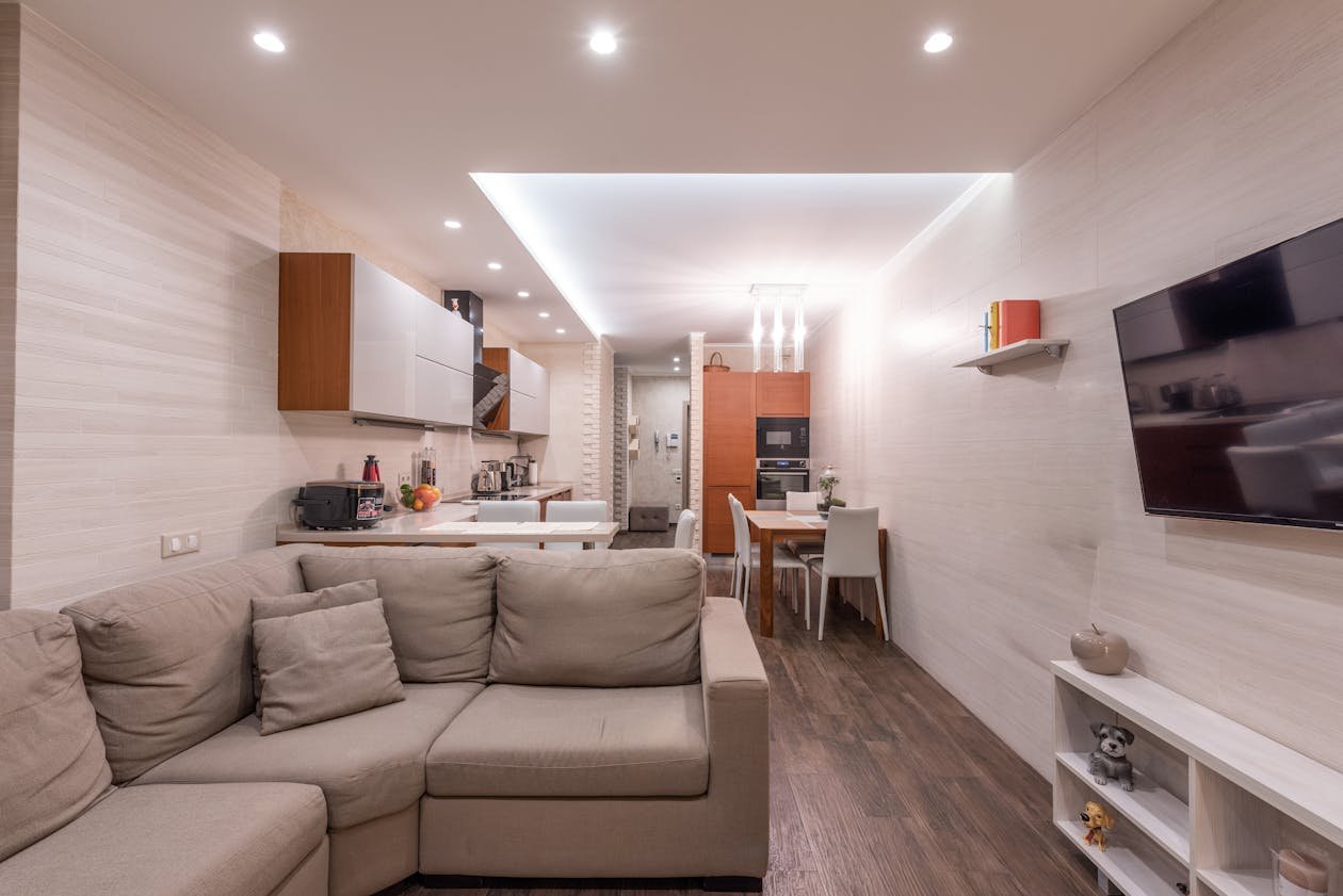 Modern studio apartment with open kitchen and living room in warm neutral tones